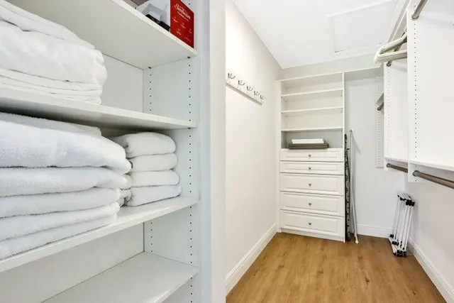 a view of walk in closet with clothes and shoes