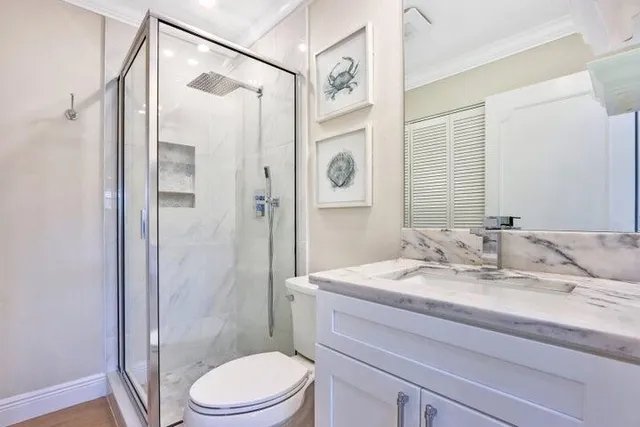 a bathroom with a sink a toilet and shower