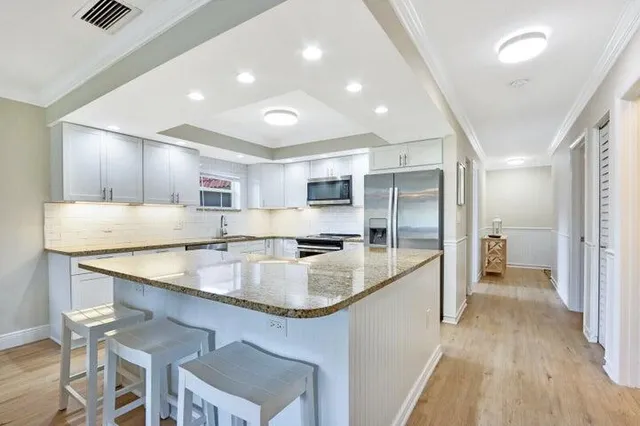 a large kitchen with stainless steel appliances kitchen island granite countertop a large counter top stainless steel appliances and cabinets