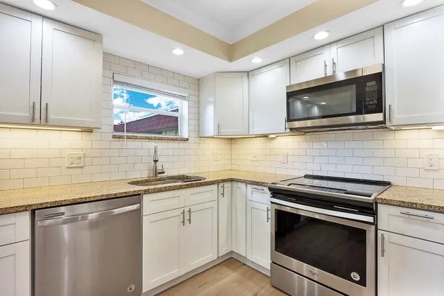 a kitchen with a sink stove and microwave