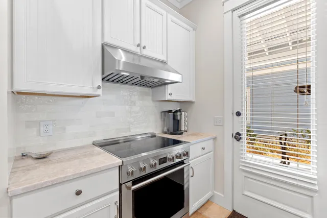 a large kitchen with a sink and dishwasher with white cabinets