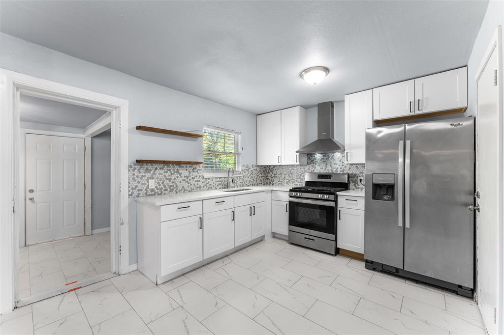 612 East 8th Street Kemp, TX 75143 - Photo 3 of 25 Kitchen featuring white shaker cabinetry, stainless steel appliances, a mosaic tile backsplash, white countertops, and large format floor tiles