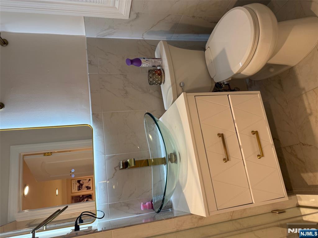 16 Lawrence Road Wayne, NJ 07470 - Photo 19 of 28 a bathroom with a sink a toilet and a mirror