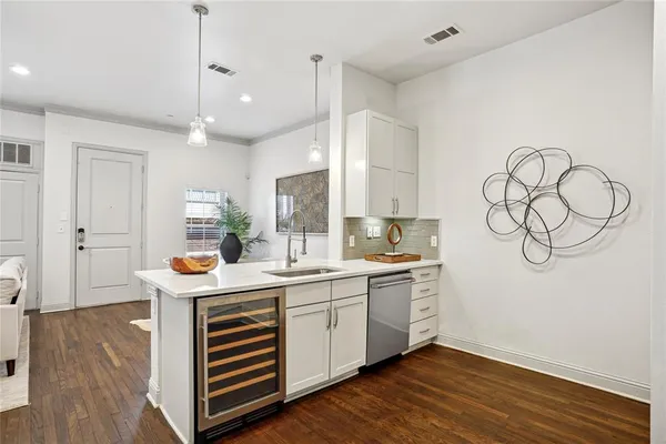 a kitchen with a sink cabinets wooden floor and stainless steel appliances