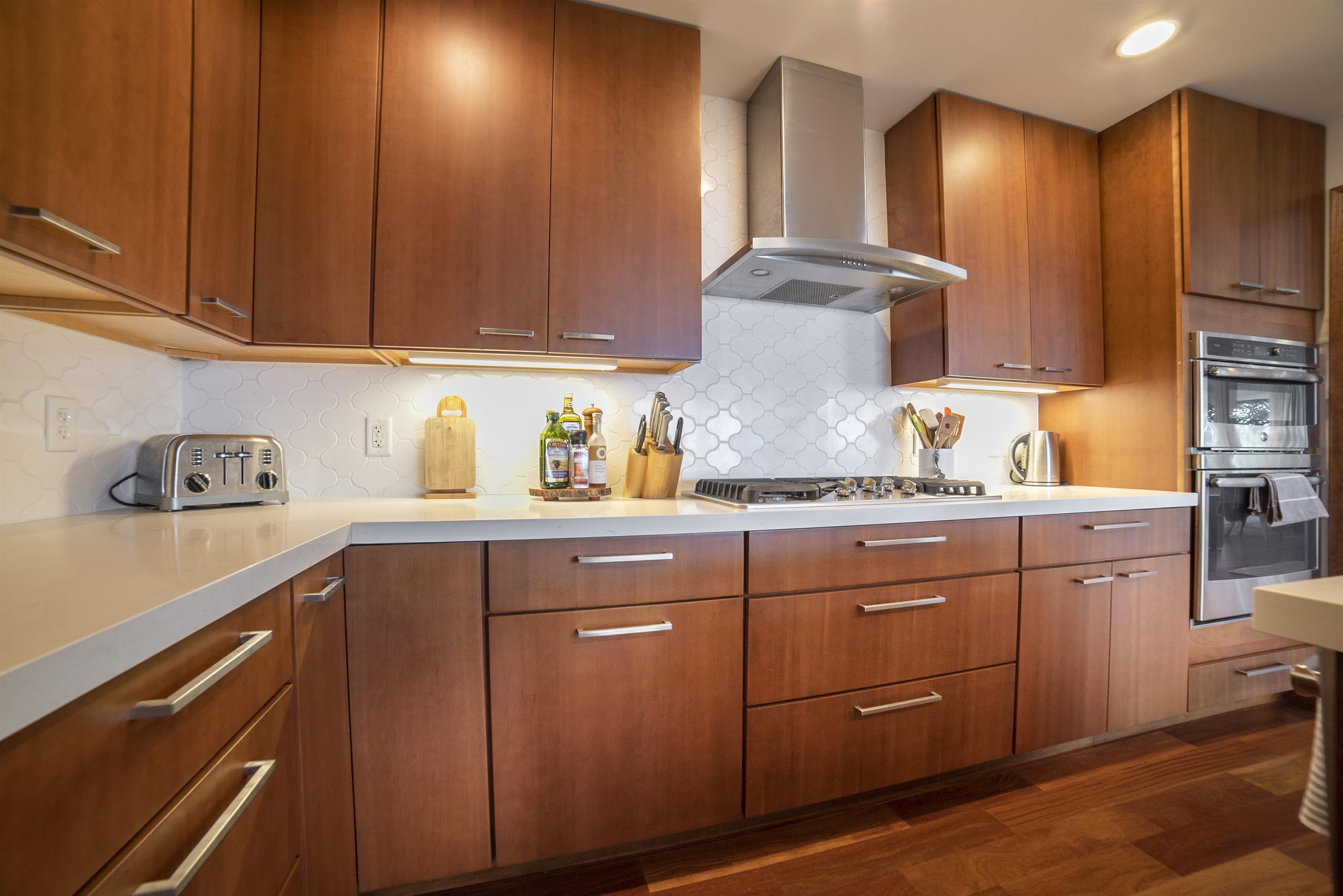 100 A Ihe Place Kula, HI 96790 - Photo 8 of 21 a kitchen with granite countertop wooden cabinets stainless steel appliances and a sink