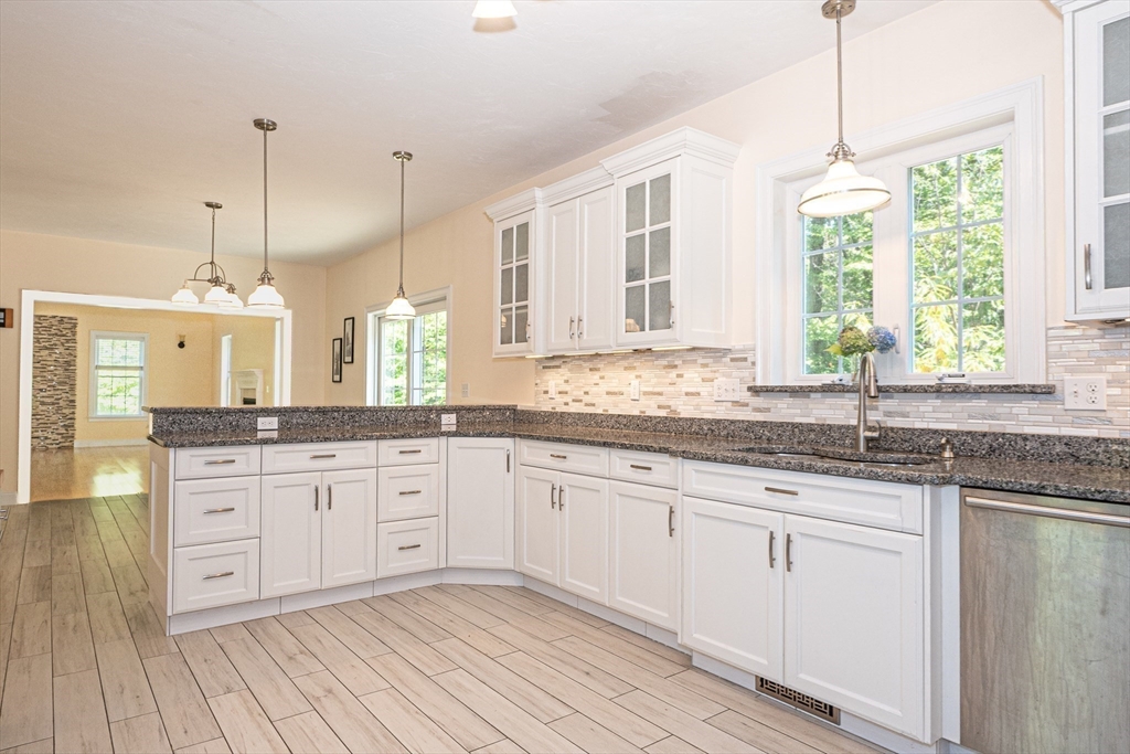 4 Farrar Road Upton, MA 01568 - Photo 9 of 37 a kitchen with granite countertop white cabinets white appliances with sink and wooden floor