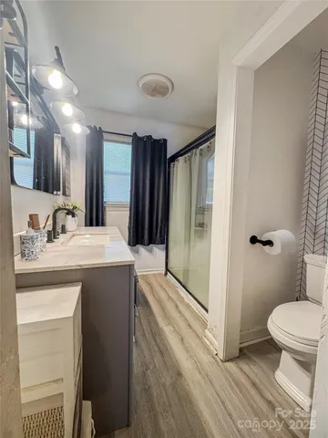 a bathroom with a sink a toilet and shower