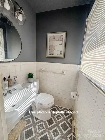 a bathroom with a granite countertop toilet sink and mirror