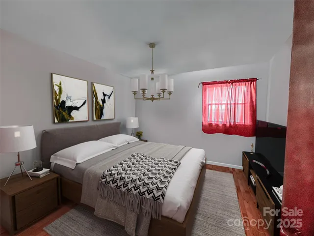 a bedroom with a bed flat screen tv on desk and a window