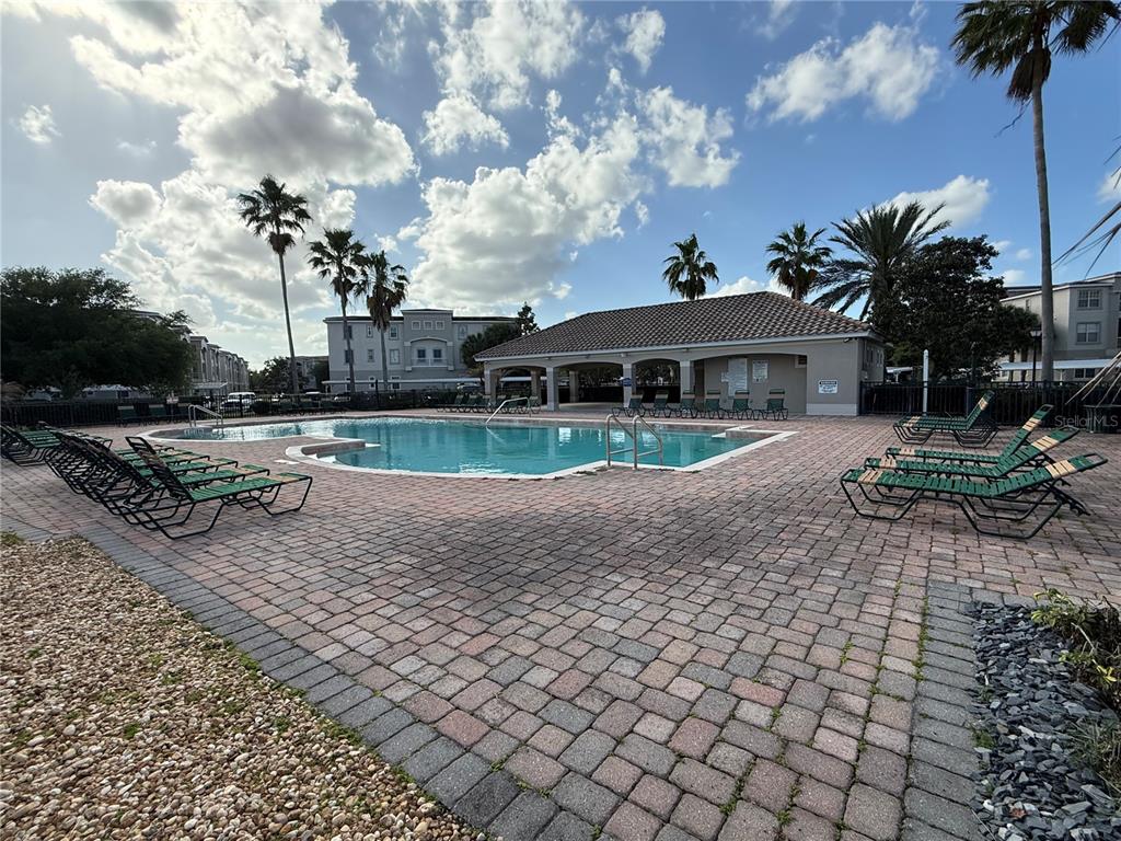 3311 Whitestone Circle, Unit 201 Kissimmee, FL 34741 - Photo 24 of 25 a view of a yard with a table and chairs under an umbrella
