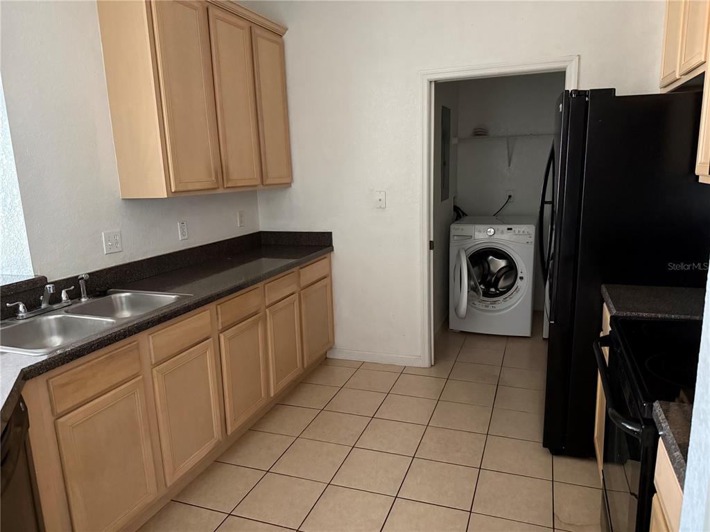 3311 Whitestone Circle, Unit 201 Kissimmee, FL 34741 - Photo 8 of 25 a kitchen with a sink a refrigerator and cabinets