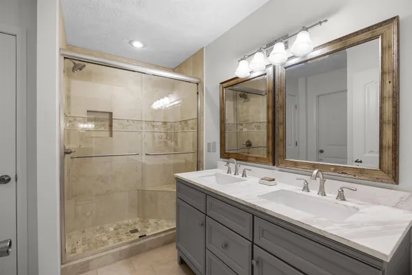 a bathroom with a shower sink and mirror