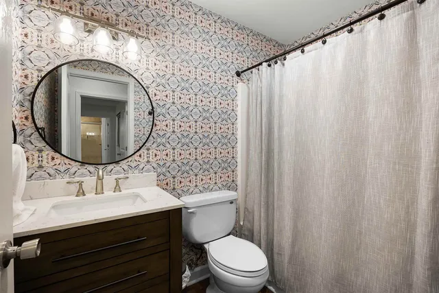 a bathroom with a sink a mirror a toilet and a mirror