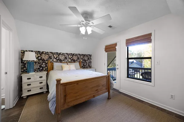 a bed sitting in a bedroom next to a window and a chandelier