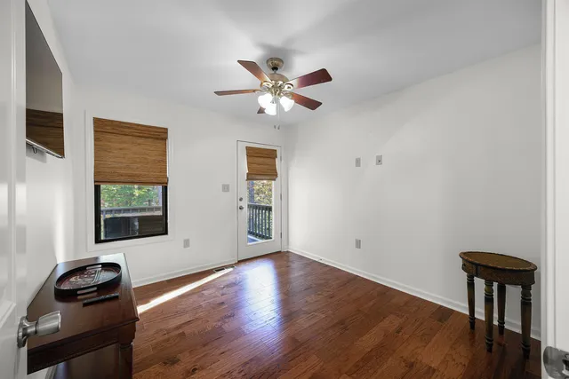a view of a livingroom with wooden floor and a ceiling fan
