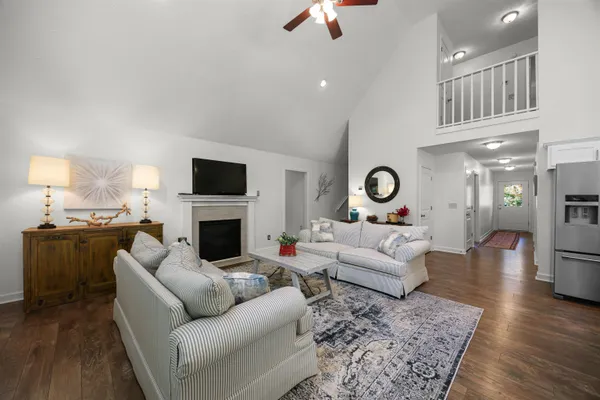 a living room with furniture a fireplace and a flat screen tv