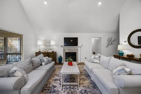 a living room with furniture a fireplace and a flat screen tv