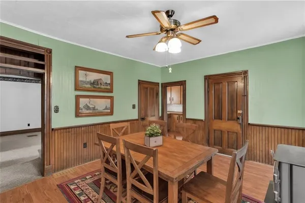 a view of a dining room with furniture and a chandelier fan