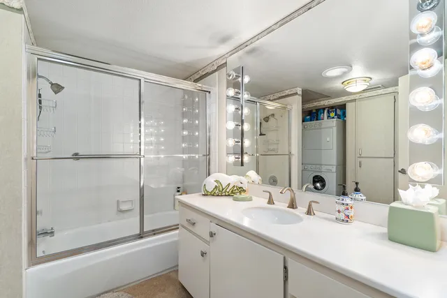 a bathroom with a shower sink vanity and mirror