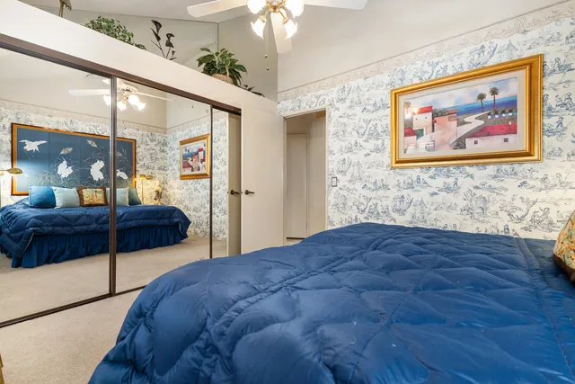 a bedroom with a large bed and a chandelier