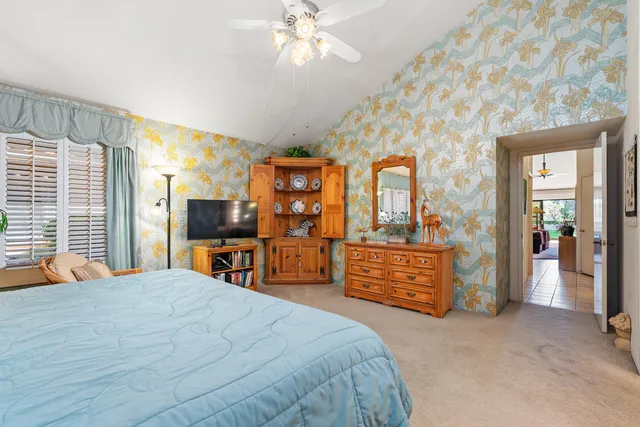 a bedroom with a large bed and a chandelier