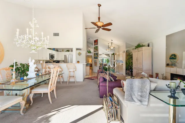 a dining room with furniture a chandelier and wooden floor