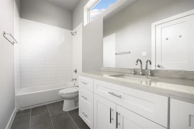 a bathroom with a granite countertop sink a toilet and a mirror