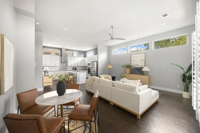 a living room with furniture and a dining table with wooden floor