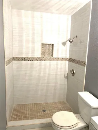 a bathroom with a toilet and a shower curtain