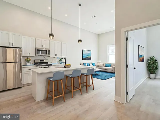 a kitchen with kitchen island a white table and chairs