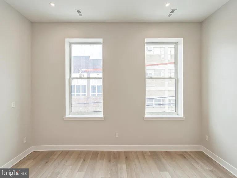 1243 North 26th Street, Unit 4 Philadelphia, PA 19121 - Photo 11 of 18 an empty room with wooden floor and windows