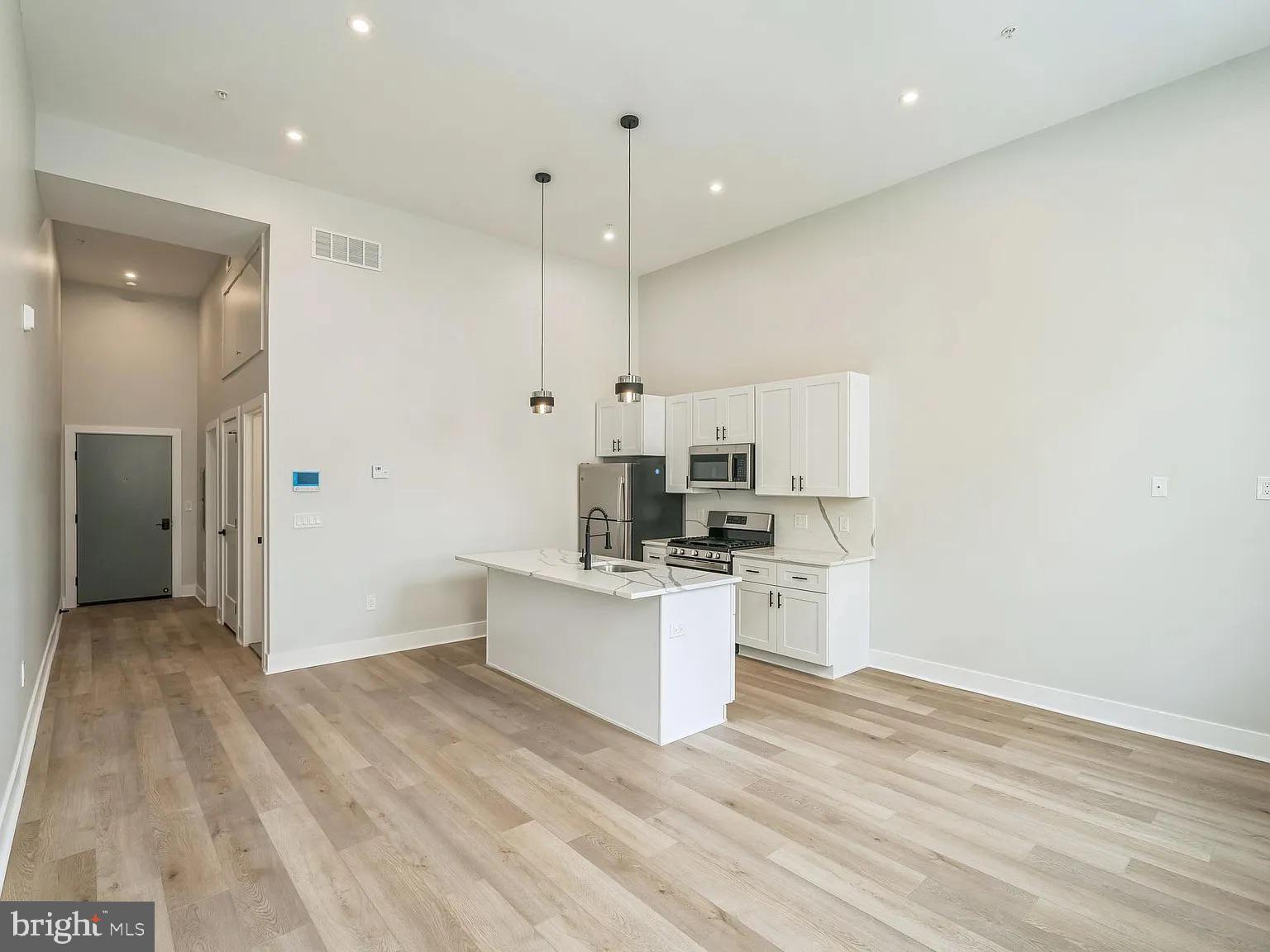 1243 North 26th Street, Unit 4 Philadelphia, PA 19121 - Photo 12 of 18 a kitchen with white cabinets and white appliances