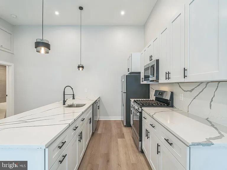 1243 North 26th Street, Unit 4 Philadelphia, PA 19121 - Photo 14 of 18 a kitchen with stainless steel appliances a sink stove and refrigerator
