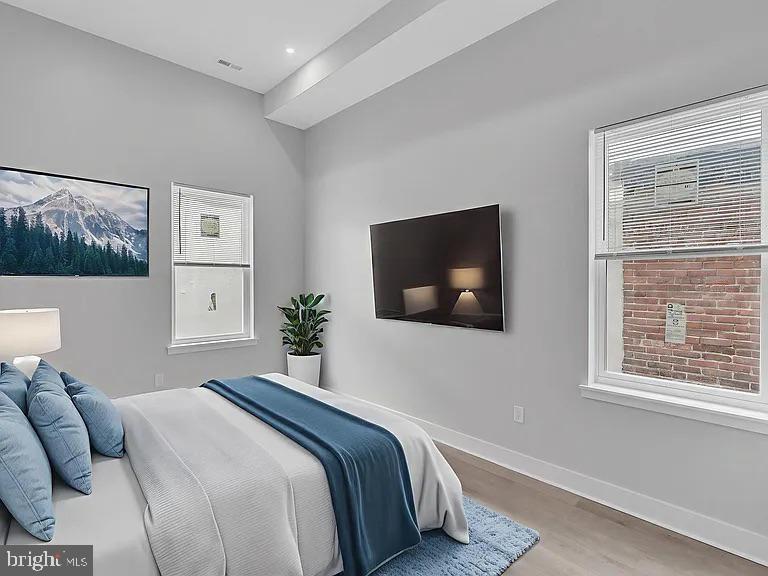 1243 North 26th Street, Unit 4 Philadelphia, PA 19121 - Photo 6 of 18 a bedroom with a large bed and a flat screen tv