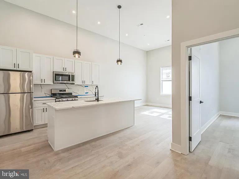 1243 North 26th Street, Unit 4 Philadelphia, PA 19121 - Photo 10 of 18 a kitchen with stainless steel appliances granite countertop a refrigerator a stove a sink and a refrigerator