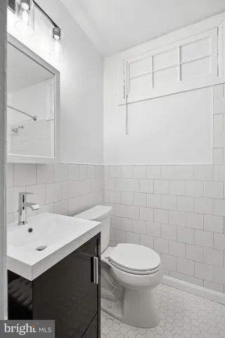 a bathroom with a sink a toilet and a mirror