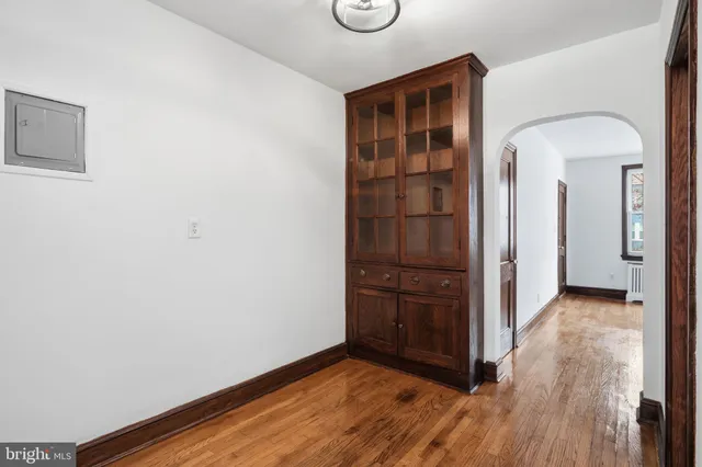 an empty room with wooden floor closet and windows