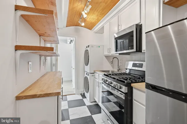 a kitchen with stainless steel appliances granite countertop a refrigerator stove and microwave