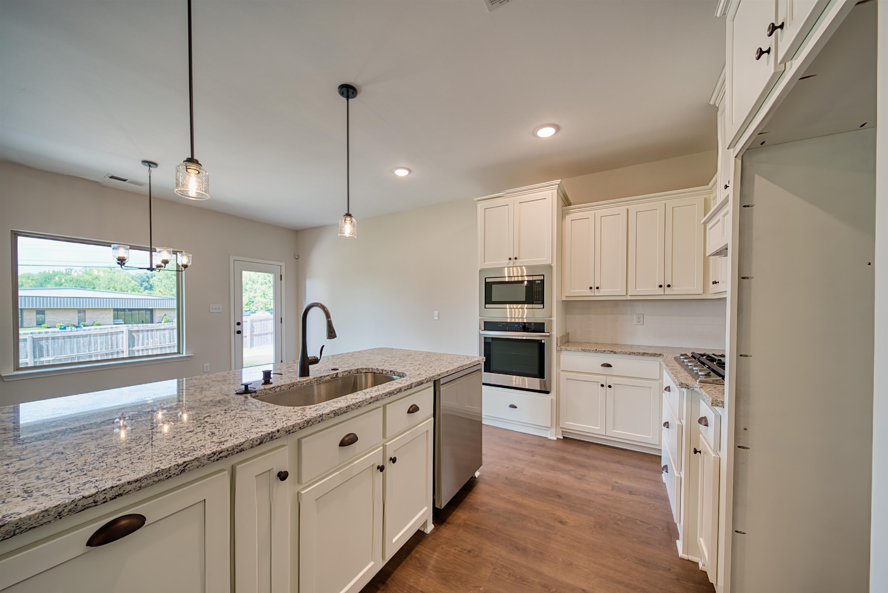 32 Forsyth Lane Munford, TN 38058 - Photo 2 of 35 a kitchen with stainless steel appliances kitchen island granite countertop a sink a stove and a refrigerator