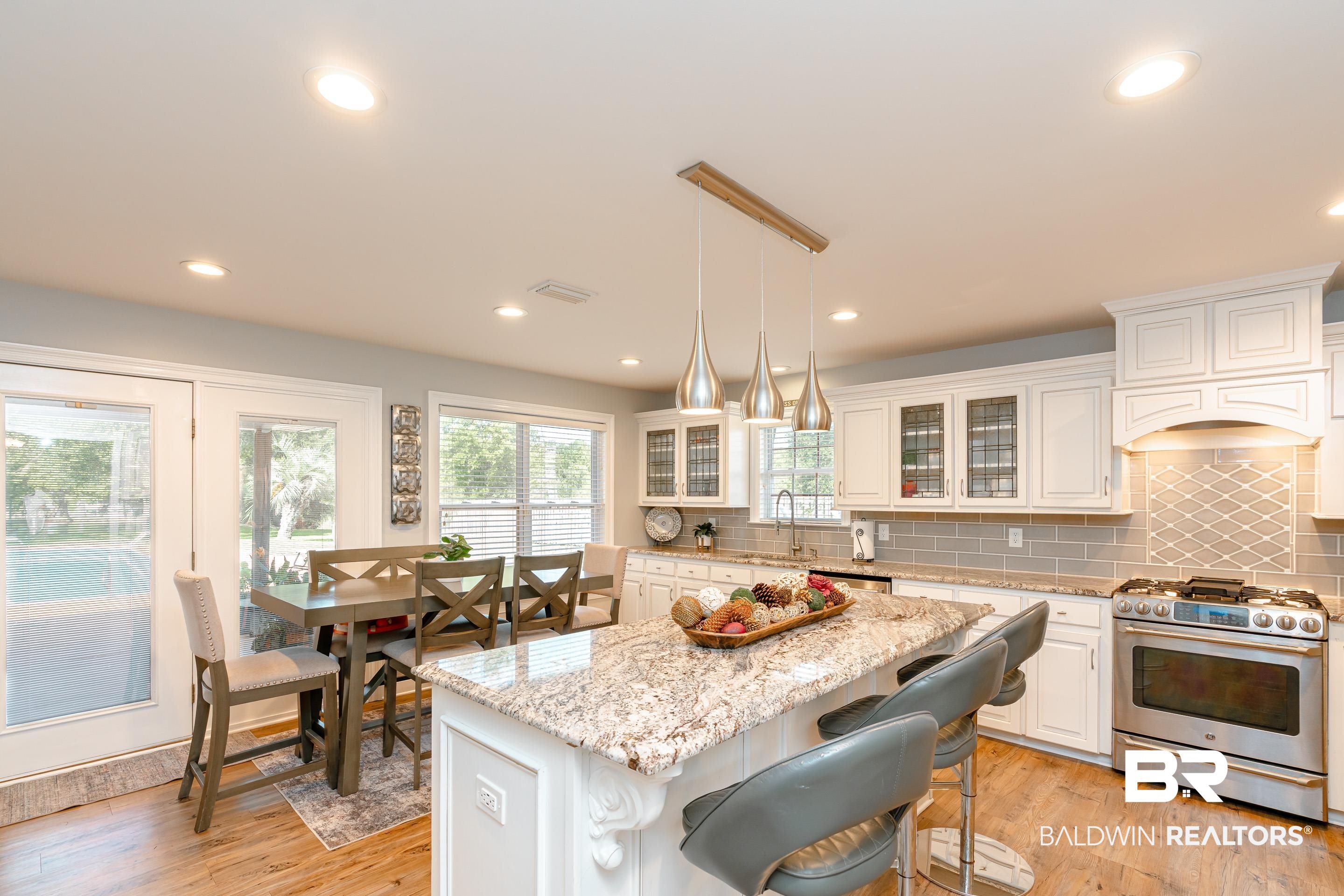 9477 Deerfield Drive Irvington, AL 36544 - Photo 9 of 58 Kitchen with tasteful backsplash, white cabinetry, appliances with stainless steel finishes, and light hardwood / wood-style floors