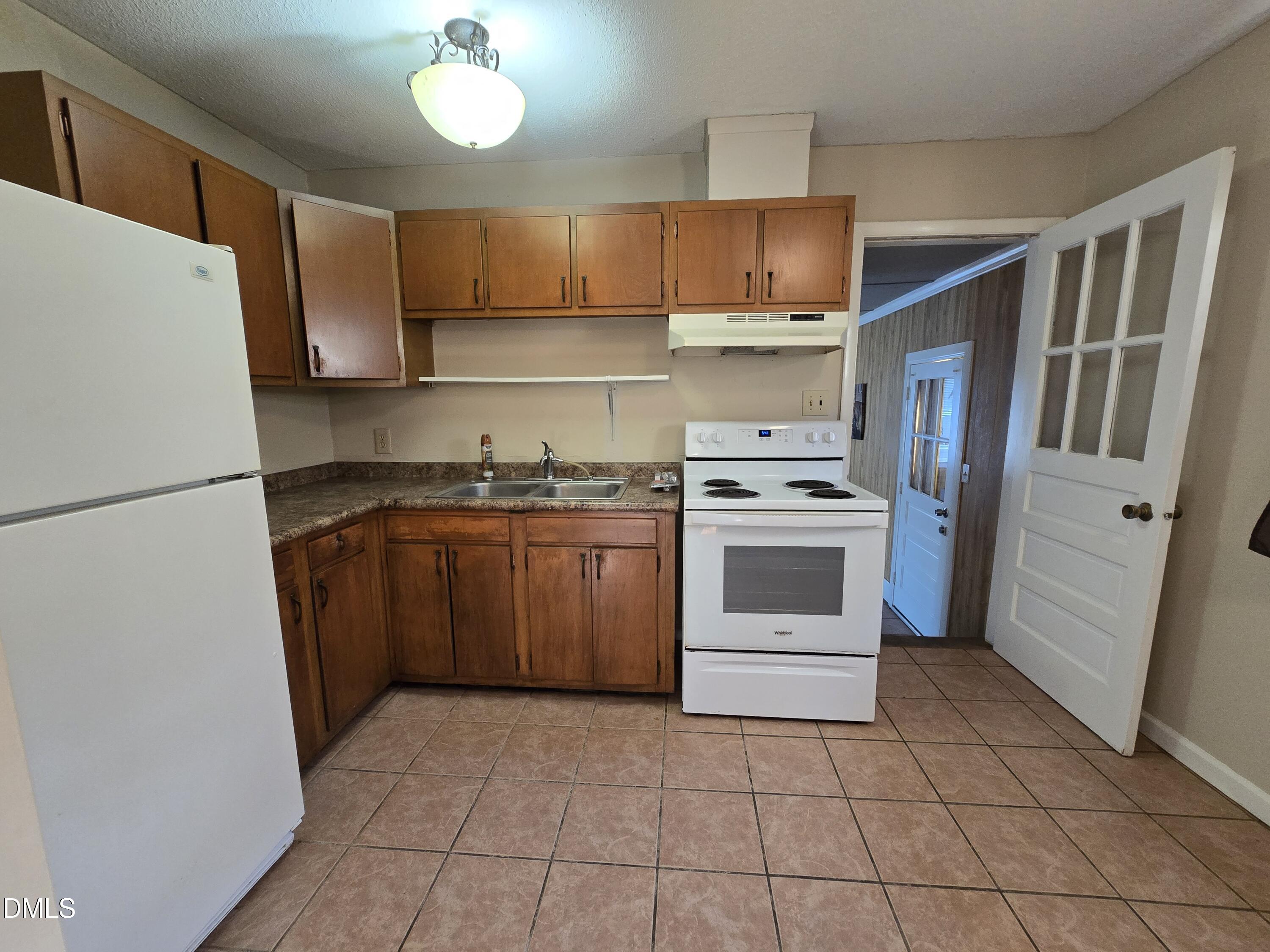 1808 Tee Dee Street Raleigh, NC 27610 - Photo 5 of 10 a kitchen with a stove a refrigerator and a sink