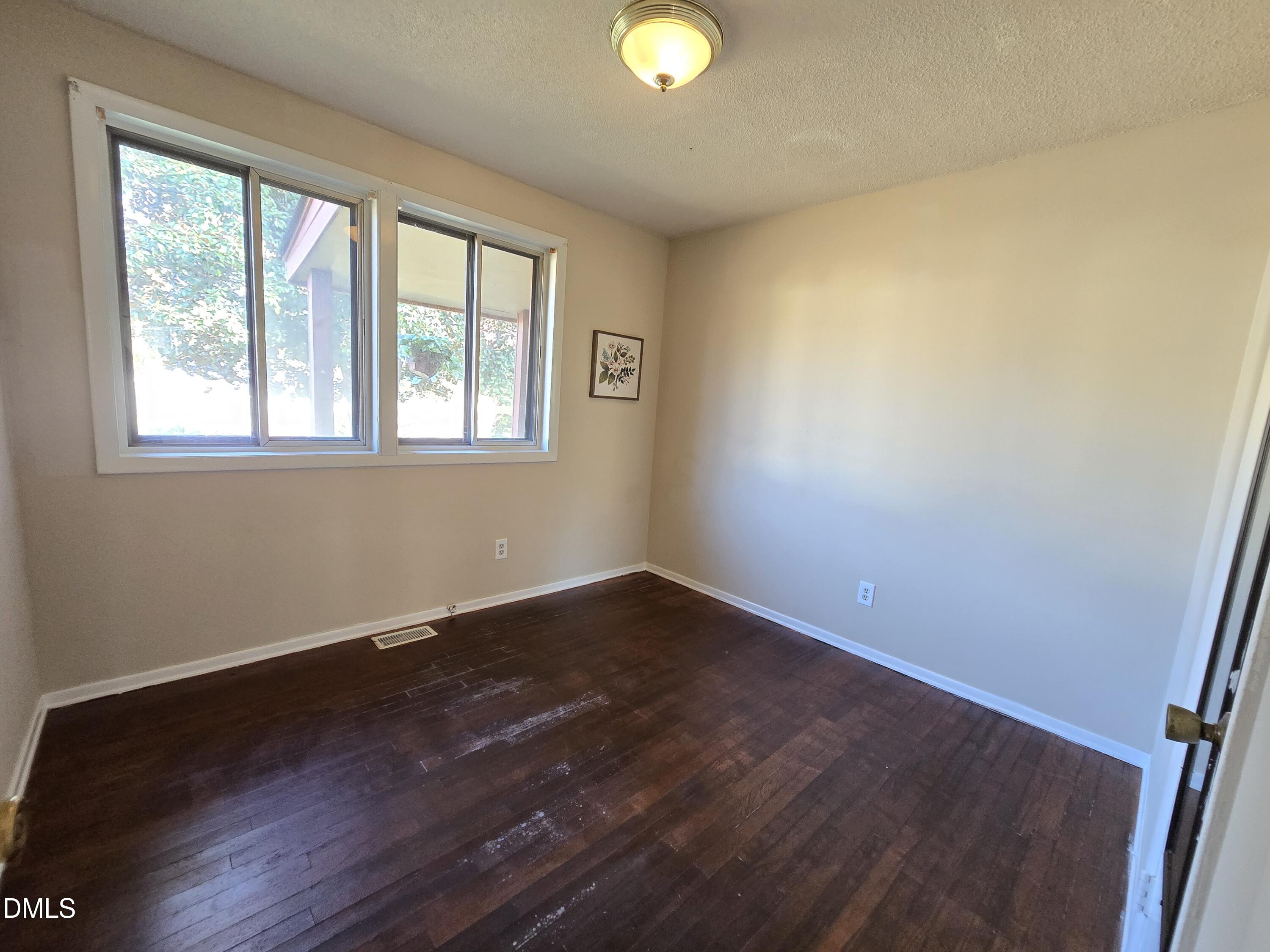 1808 Tee Dee Street Raleigh, NC 27610 - Photo 10 of 10 an empty room with wooden floor and windows