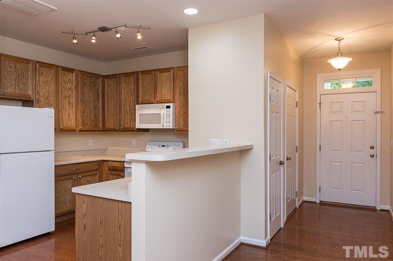 8249 Martello Lane Raleigh, NC 27613 - Photo 4 of 18 a kitchen with a sink stainless steel appliances a refrigerator and cabinets