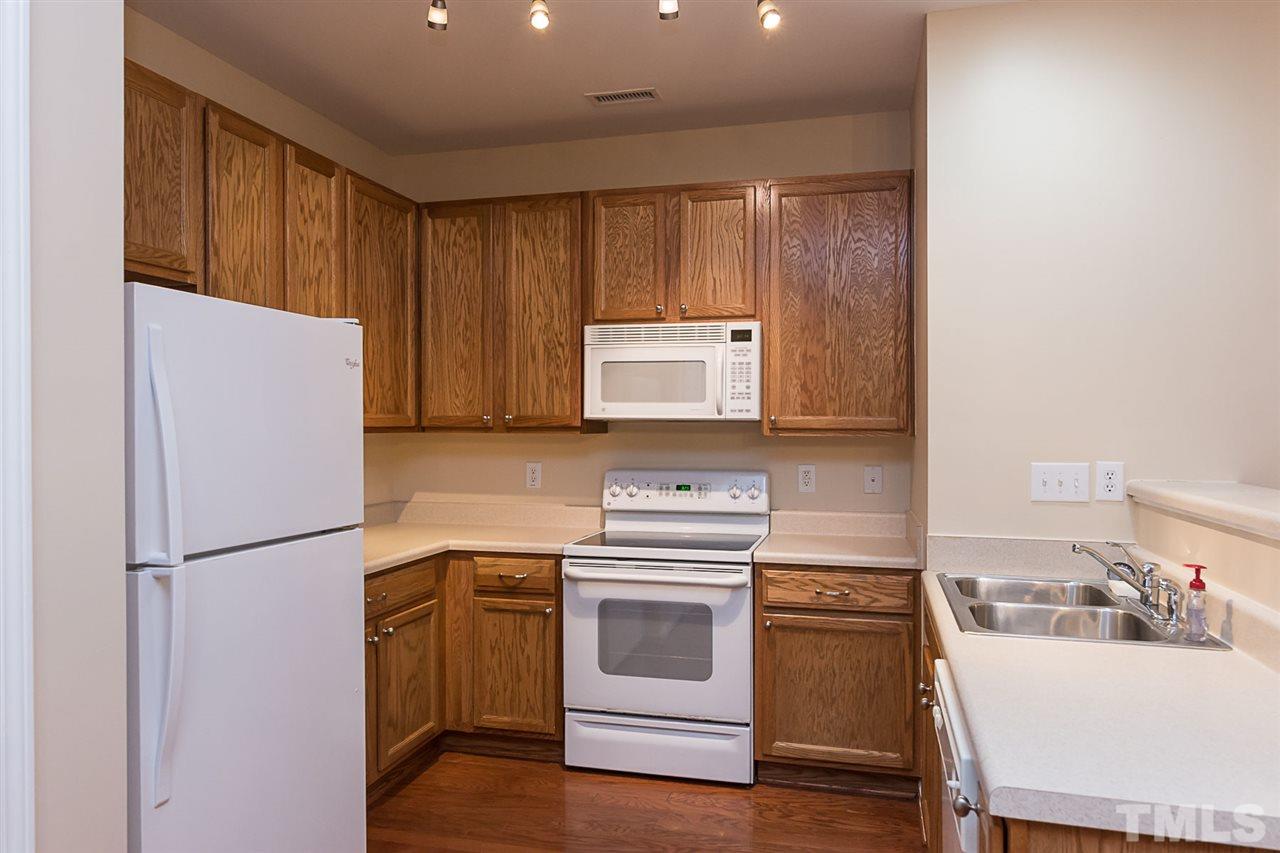 8249 Martello Lane Raleigh, NC 27613 - Photo 6 of 18 a kitchen with a refrigerator sink and stove