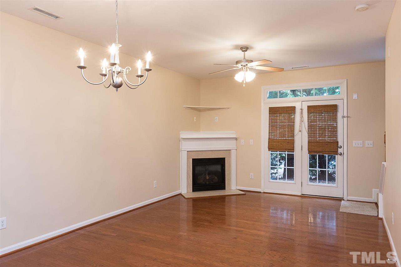 8249 Martello Lane Raleigh, NC 27613 - Photo 7 of 18 a view of a room with chandelier fan and fireplace