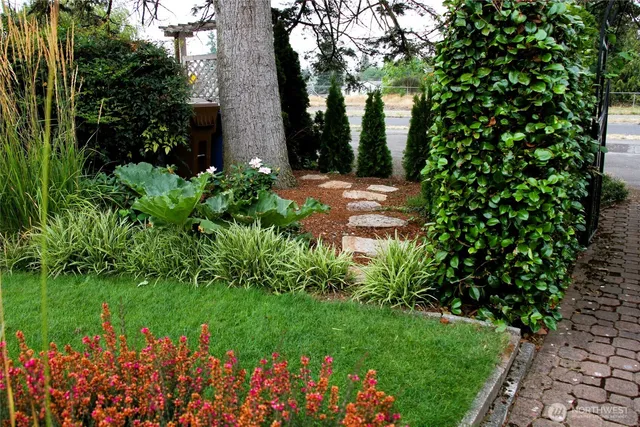 a view of garden with flowers and trees