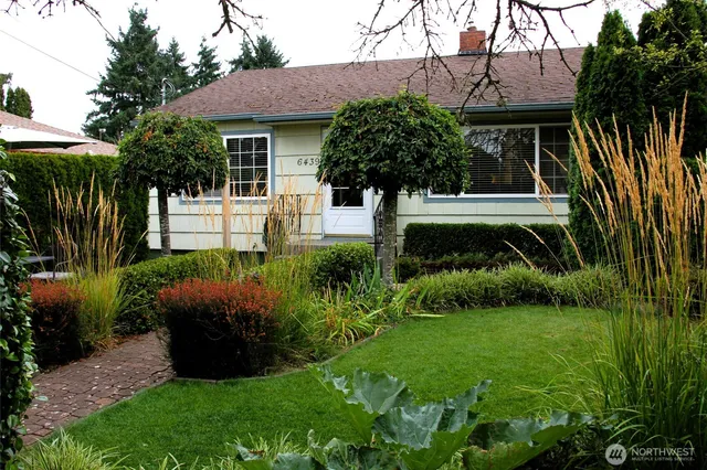 a front view of a house with a yard and potted plants