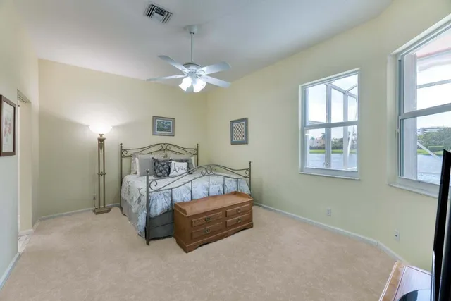 a spacious bedroom with a bed mirror and window