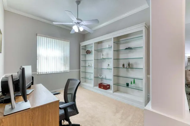 a view of a workspace with furniture and a window