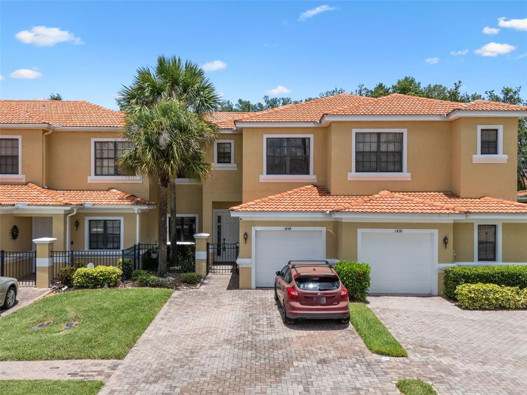 a front view of a house with a garden and parking
